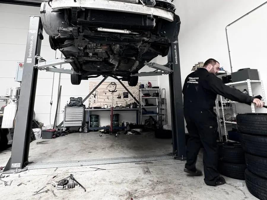 Auto op de hefbrug in de werkplaats van Prima Auto's
